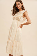 Woman wearing a beige lace dress against a plain background